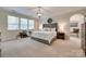 Serene primary bedroom with a large window, neutral tones, sitting area and decorative lighting at 2205 Gallberry Ln, Waxhaw, NC 28173