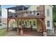 Two story home with yellow siding, red brick facade, and a backyard with multiple decks at 2308 Blair House Ct, Charlotte, NC 28270