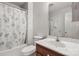 Cozy bathroom with tub, wooden vanity, floral curtain, and white and gray textured walls at 2308 Blair House Ct, Charlotte, NC 28270