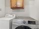 Laundry room with a modern washer, dryer, and wooden cabinet at 2308 Blair House Ct, Charlotte, NC 28270