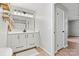 Bathroom featuring white vanity with modern lighting and a doorway leading to a bedroom with wood-look floors at 3372 Lee Lawing Rd, Lincolnton, NC 28092
