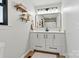 Bathroom featuring white vanity with a speckled countertop, shelving, and a large mirror with modern lighting at 3372 Lee Lawing Rd, Lincolnton, NC 28092