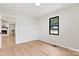 This bedroom features wood-look floors, neutral paint, and a doorway leading to a living room with a fireplace at 3372 Lee Lawing Rd, Lincolnton, NC 28092
