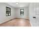 This bedroom features wood-look floors, two windows, neutral paint, and a doorway leading to another room at 3372 Lee Lawing Rd, Lincolnton, NC 28092