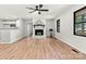 Bright living room features a brick fireplace, ceiling fan, and wood-look flooring at 3372 Lee Lawing Rd, Lincolnton, NC 28092