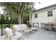 This back deck has patio furniture, including chairs, rocking chairs, a couch, tables, and a grill at 4126 Tyndale Ave, Charlotte, NC 28210
