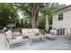 The back deck has patio seating and an umbrella. Mature shade trees provide privacy at 4126 Tyndale Ave, Charlotte, NC 28210