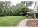 Expansive backyard with a manicured lawn, mature trees, and a stone pathway at 4126 Tyndale Ave, Charlotte, NC 28210