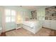Cozy bedroom featuring built-in bookshelves, neutral decor, and bright natural light from two windows at 4126 Tyndale Ave, Charlotte, NC 28210
