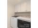 This laundry room features white cabinets, a washer and dryer set, and patterned tile flooring at 4126 Tyndale Ave, Charlotte, NC 28210
