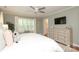 Well-lit main bedroom with a ceiling fan, a wall-mounted TV, and a full dresser in the background at 4126 Tyndale Ave, Charlotte, NC 28210