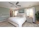 Comfortable main bedroom with a ceiling fan, neutral tones, and windows dressed with white curtains at 4126 Tyndale Ave, Charlotte, NC 28210