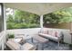 The covered porch includes a seating area with neutral colored furniture and blue cushions at 4126 Tyndale Ave, Charlotte, NC 28210