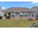 A back exterior view featuring a covered patio, windows, and partial brick accents at 4427 Poplin Grove Dr, Indian Trail, NC 28079
