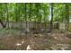 Inviting backyard fire pit surrounded by mature trees and a wooden privacy fence perfect for outdoor entertaining at 4439 Brandie Glen Rd, Charlotte, NC 28269