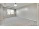 Spacious primary bedroom featuring neutral carpet, tray ceiling and large window at 5033 Mockernut Ln, Indian Land, SC 29707