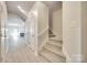 Inviting hallway with staircase leading to the upper level and modern, neutral decor at 5033 Mockernut Ln, Indian Land, SC 29707