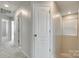 Hallway with carpet, neutral walls, a window, and white doors leading to other rooms at 5033 Mockernut Ln, Indian Land, SC 29707