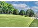 Spacious backyard featuring a sprawling lawn and mature trees, offering privacy and ample space for activities at 604 Palmerston Ln, Waxhaw, NC 28173