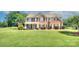 Beautiful brick two-story home with lush green lawn and mature landscaping, perfect for Gathering living at 604 Palmerston Ln, Waxhaw, NC 28173
