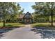 Stately home with Tudor-style architecture, mature trees, and a well-maintained front yard, creating a picturesque setting at 604 Palmerston Ln, Waxhaw, NC 28173