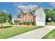 Charming brick and siding home with a manicured lawn, long driveway, and basketball hoop for outdoor enjoyment at 604 Palmerston Ln, Waxhaw, NC 28173