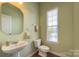 Bright powder room with pedestal sink, toilet and decorative mirror at 604 Palmerston Ln, Waxhaw, NC 28173