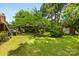 Spacious backyard featuring lush lawn, mature trees, and storage shed for outdoor enjoyment at 7501 Glencannon Dr, Charlotte, NC 28227
