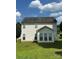 Spacious backyard with green grass, backing of the house, and a sunroom with large windows at 8125 Weeping Fig Ln, Charlotte, NC 28215