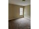 Cozy carpeted bedroom featuring a window with blinds and neutral-toned walls at 8125 Weeping Fig Ln, Charlotte, NC 28215