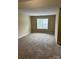 Spacious bedroom with neutral walls, carpeted floors, and natural light from the window with blinds at 8125 Weeping Fig Ln, Charlotte, NC 28215