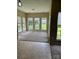 Bright sunroom with a wall of windows and neutral carpet, creating an open and inviting space at 8125 Weeping Fig Ln, Charlotte, NC 28215