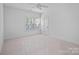 Neutral bedroom features window, ceiling fan and door at 8303 Adrian Ct, Charlotte, NC 28270