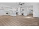 Spacious open-concept kitchen and living area with wood floors, white cabinets, and modern appliances at 8303 Adrian Ct, Charlotte, NC 28270