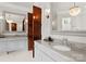 Well-lit bathroom featuring dual sinks, marble countertops, and modern fixtures at 8500 Longview Club Dr, Waxhaw, NC 28173