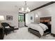 Bedroom with a large window, chair, and elegant chandelier at 8500 Longview Club Dr, Waxhaw, NC 28173