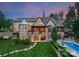 Sprawling home showcasing a balcony, covered outdoor seating, and a well-manicured lawn leading to a private pool area at 8500 Longview Club Dr, Waxhaw, NC 28173