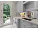 Well-lit laundry room with modern washer and dryer, sink, and access to the backyard at 8500 Longview Club Dr, Waxhaw, NC 28173