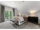Comfortable main bedroom with french doors, neutral tones and stylish furnishings at 8500 Longview Club Dr, Waxhaw, NC 28173