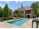 Luxury home exterior with in-ground pool, lounge furniture and manicured landscaping at 8500 Longview Club Dr, Waxhaw, NC 28173