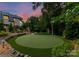 Private backyard putting green surrounded by lush landscaping, perfect for golf enthusiasts and outdoor recreation at 8500 Longview Club Dr, Waxhaw, NC 28173