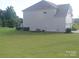 Large backyard with green grass and a view of the home's siding and roof at 858 Oak Manor Se Dr, Concord, NC 28025