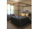A well-lit bedroom featuring a four-poster bed with decorative yellow pillows, complemented by a yellow side table at 858 Oak Manor Se Dr, Concord, NC 28025