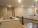 Upstairs hallway with wood and wrought iron railing, fan, and neutral walls at 858 Oak Manor Se Dr, Concord, NC 28025