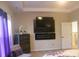Calming bedroom features an electric fireplace, large windows, and a tray ceiling at 858 Oak Manor Se Dr, Concord, NC 28025