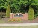 Community entrance sign with brick base and manicured flower beds below at 858 Oak Manor Se Dr, Concord, NC 28025