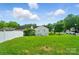Expansive backyard featuring lush green grass, mature trees, and a home with ample natural light at 8604 Rockmoor Ridge Rd, Charlotte, NC 28215