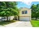Charming yellow two-story home featuring a two-car garage, blue shutters, a well-manicured lawn, and mature trees at 8604 Rockmoor Ridge Rd, Charlotte, NC 28215
