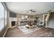 This is a virtually staged living room featuring hardwood floors, a fireplace, neutral-colored walls, and staircase at 8604 Rockmoor Ridge Rd, Charlotte, NC 28215