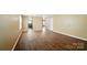 Empty living room featuring hardwood floors, neutral-colored walls, and a white doorway at 8604 Rockmoor Ridge Rd, Charlotte, NC 28215